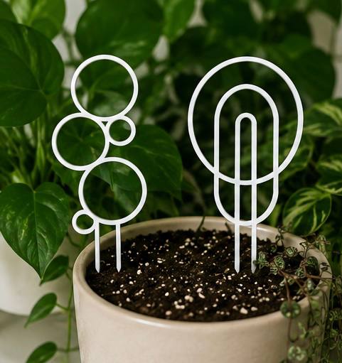 White 3D printed circular plant trellises styled in a potted plant