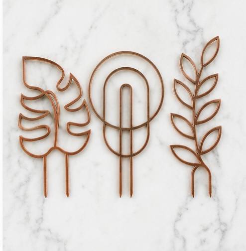 Copper monstera leaf circular arch and leafy vine 3D printed trellises on marble background